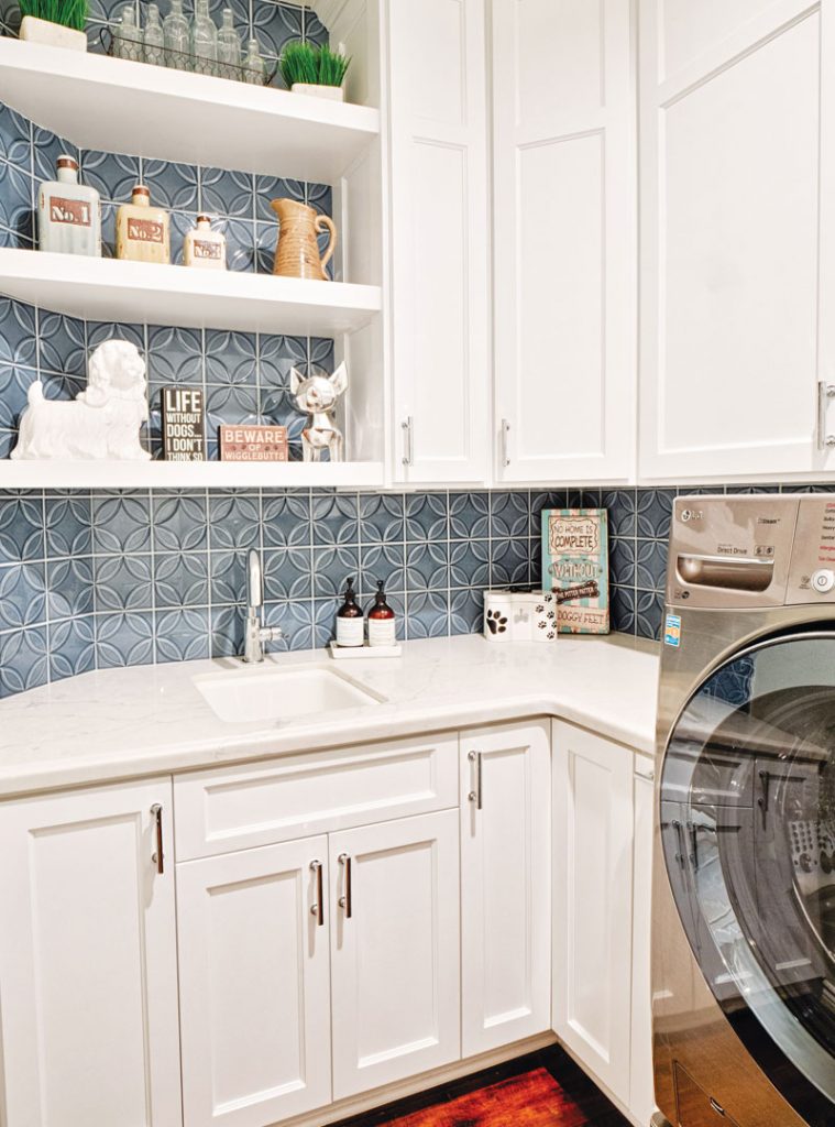 This image depicts a bright and modern laundry room featuring a durable quartz countertop, offering a sleek and functional workspace.